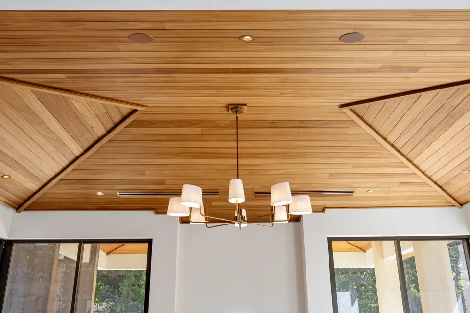 Geometric wood ceiling with angled corners and a central pendant light