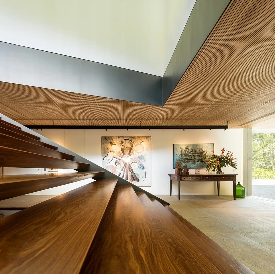 Wood ceiling meeting a sculptural stair and an open-plan interior