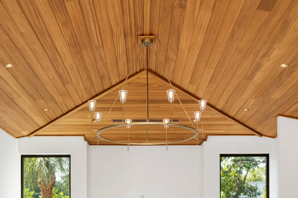 Vaulted wood ceiling with a circular chandelier and glazed openings below