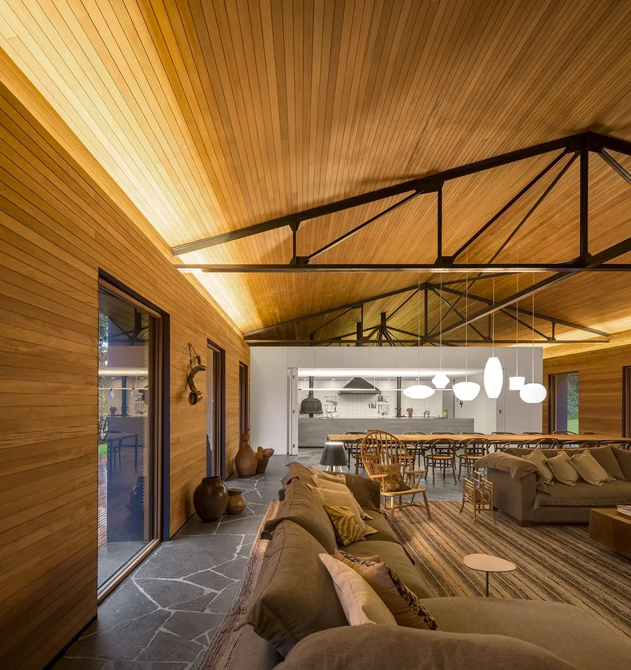 Vaulted wood ceiling over a finished living and dining space with dark roof trusses