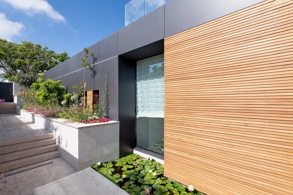 Fine horizontal wood cladding beside dark glazing and landscaped entrance steps
