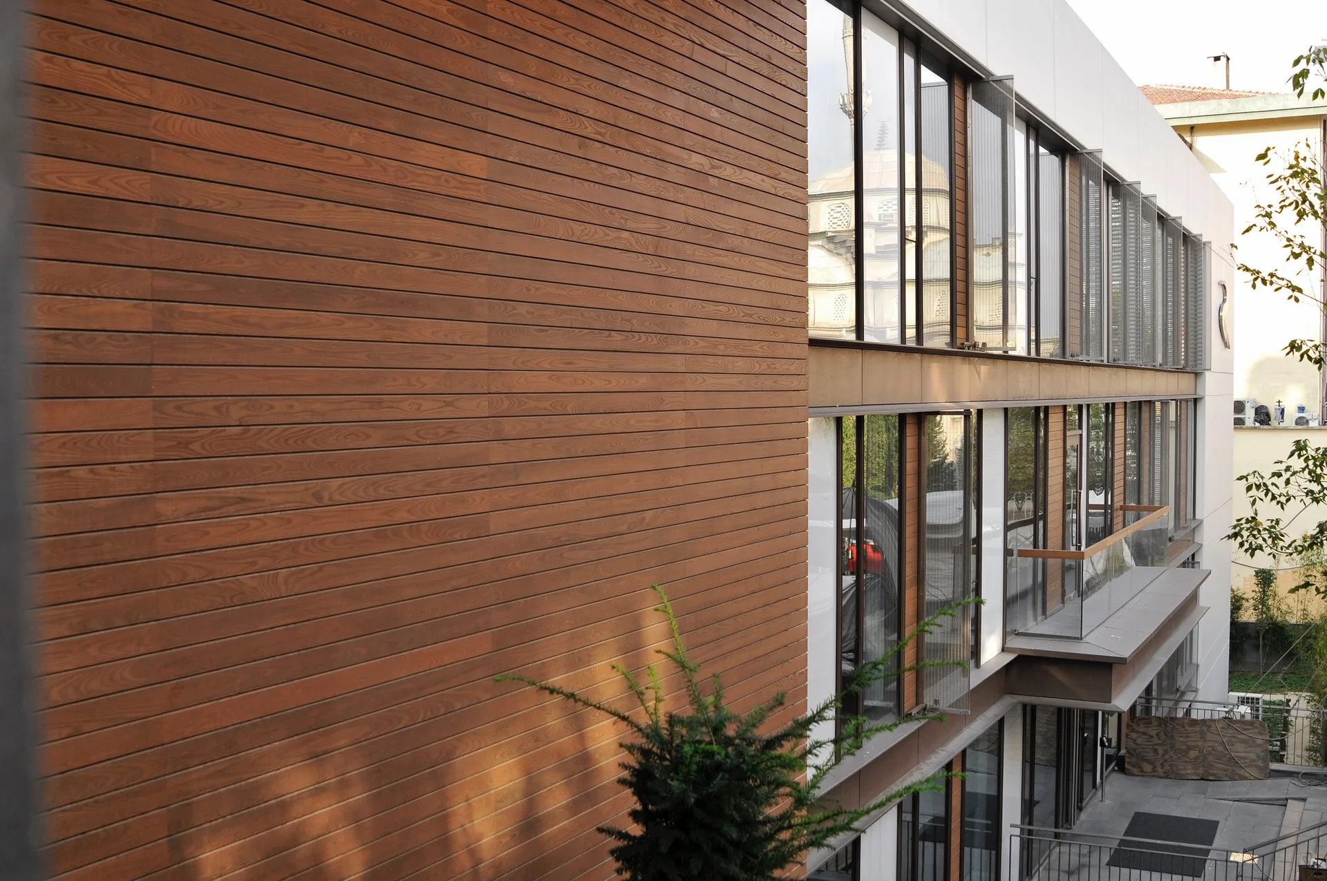 Close architectural view of horizontal wood cladding beside a tall glazed facade