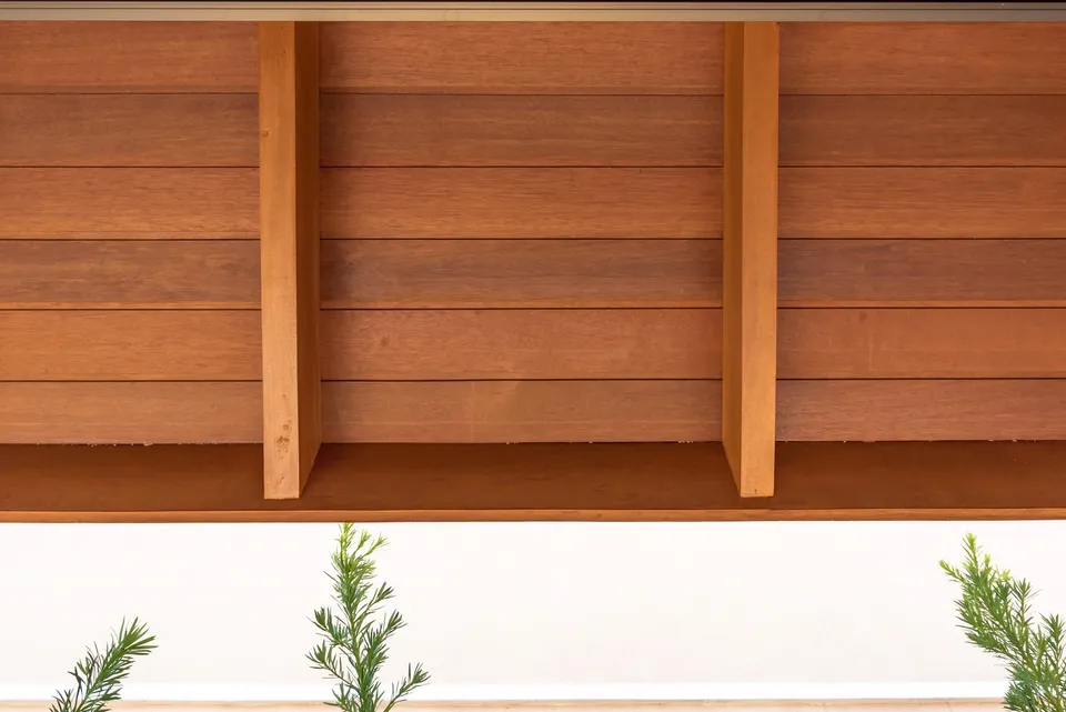 Close view of horizontal wood soffit boards supported between exposed members