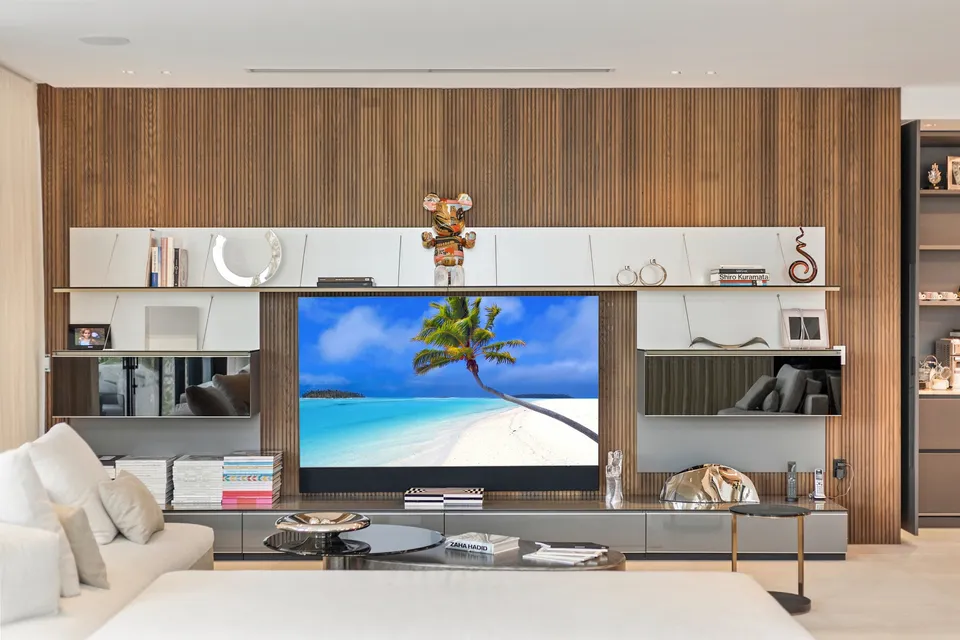 Wood feature wall behind a media console and shelving in a living room