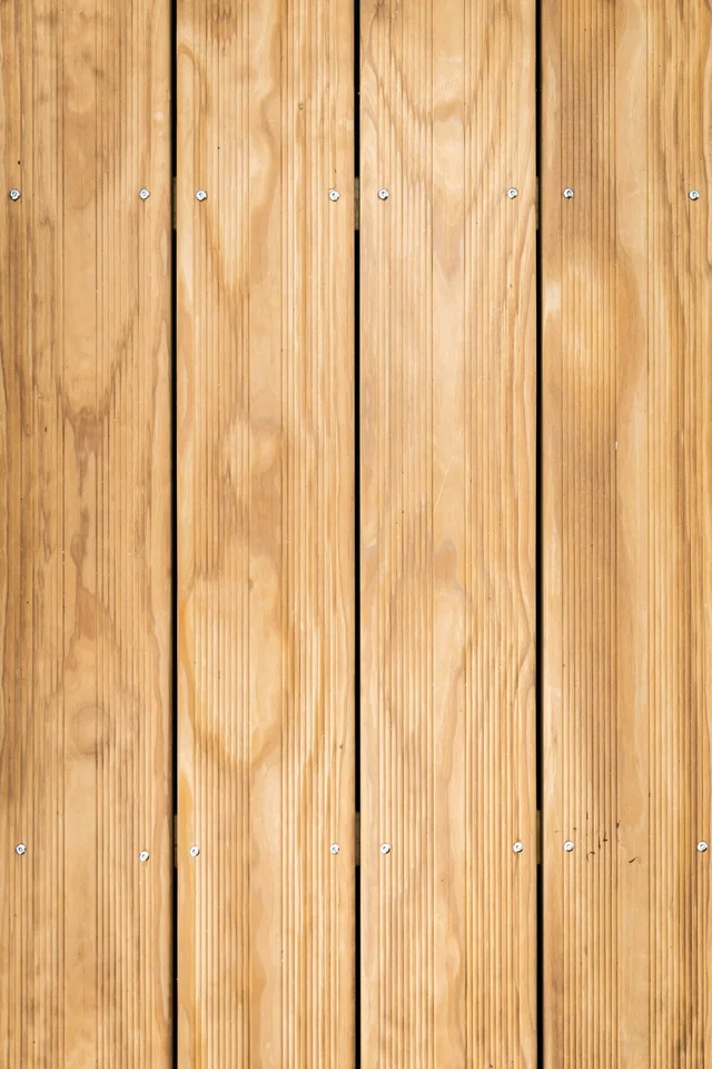 Close view of warm-toned wood boards with visible grain, joints and face fasteners