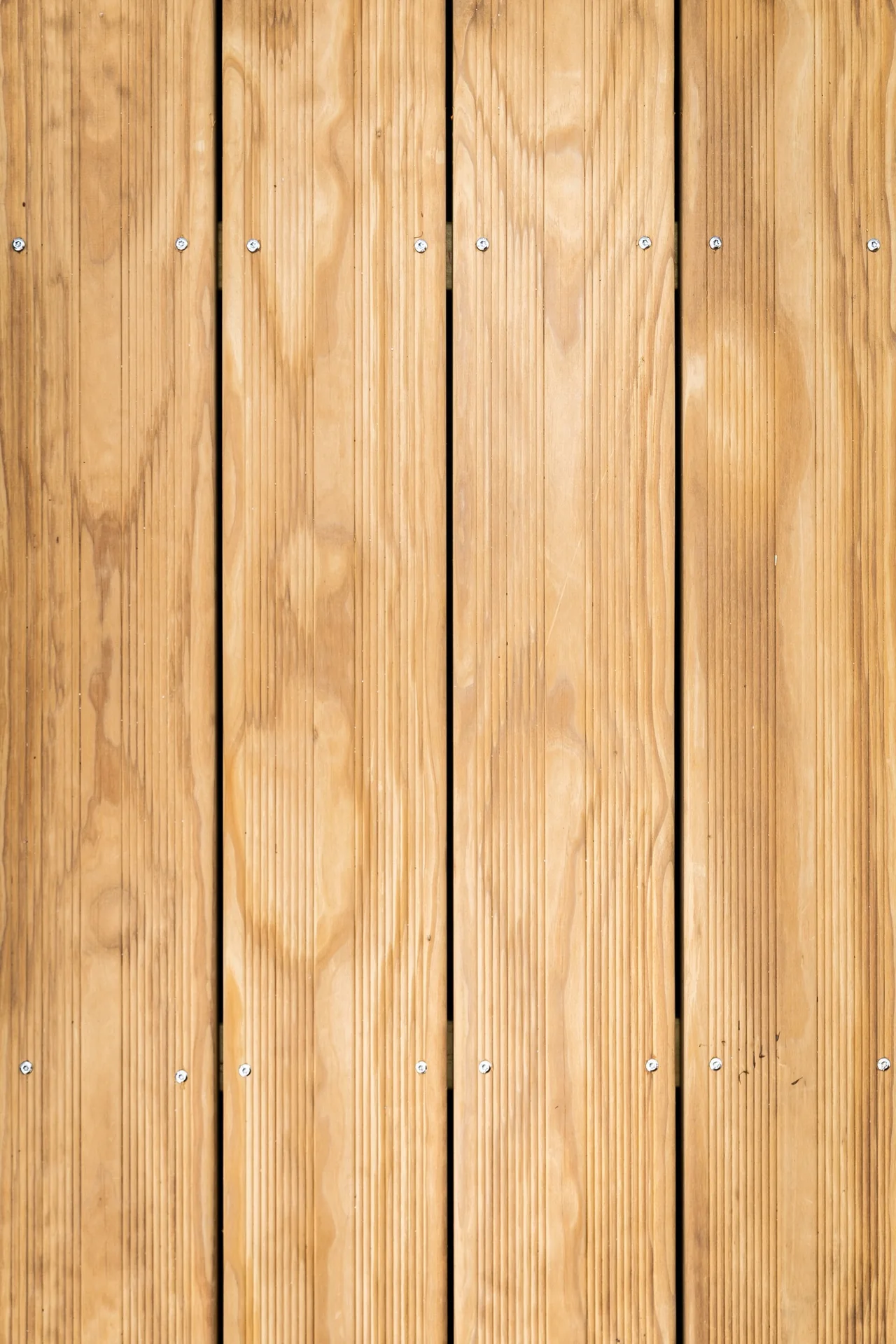 Close view of warm-toned wood boards with visible grain, joints and face fasteners